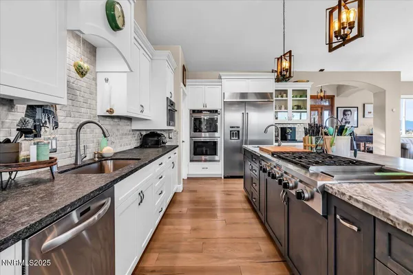 a large kitchen with stainless steel appliances granite countertop a stove and a sink