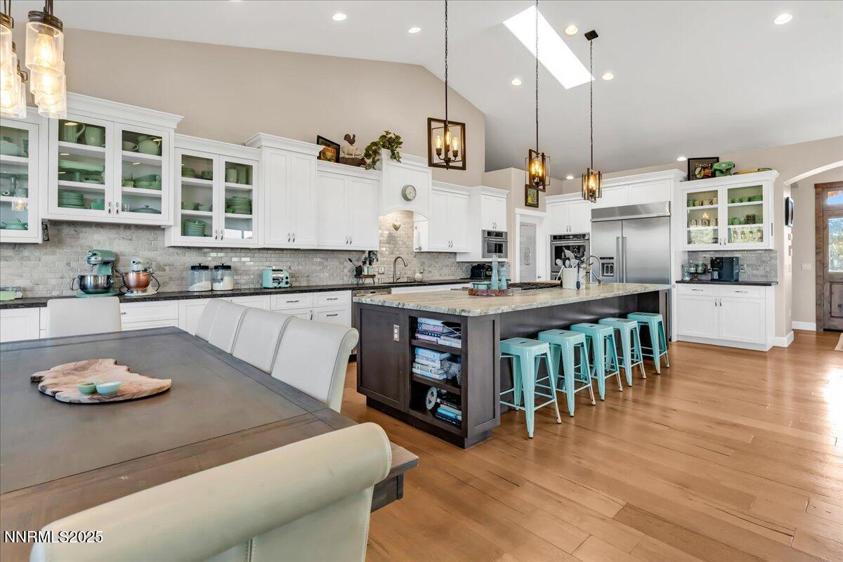 4610 Tybo Road Reno, NV 89521 - Photo 14 of 47 a kitchen with stainless steel appliances granite countertop a sink dishwasher a stove and a dining table with wooden floor