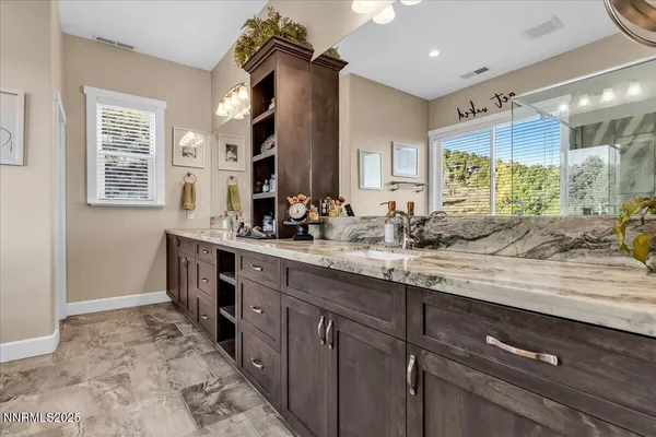 a bathroom with double vanity and a mirror
