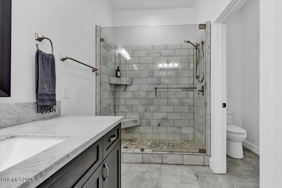 4610 Tybo Road Reno, NV 89521 - Photo 32 of 47 a bathroom with a granite countertop sink a toilet and shower