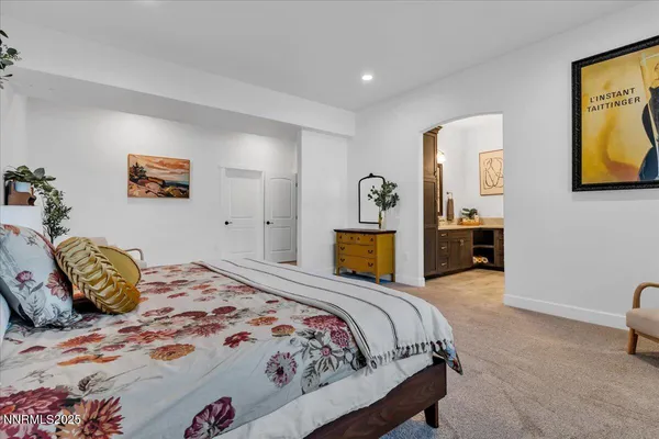 a bedroom with a bed and painting on the wall