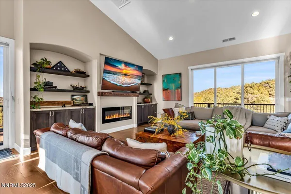 a living room with furniture a flat screen tv and a fireplace