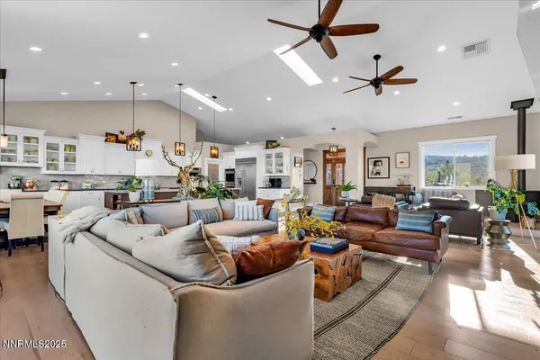 a living room with furniture kitchen view and a wooden floor