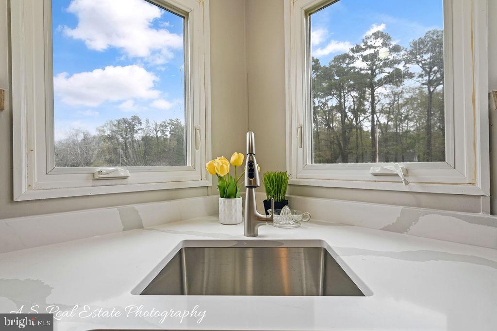 34820 Bi State Boulevard Delmar, DE 19940 - Photo 5 of 15 a kitchen with a sink and a large mirror next to a yard