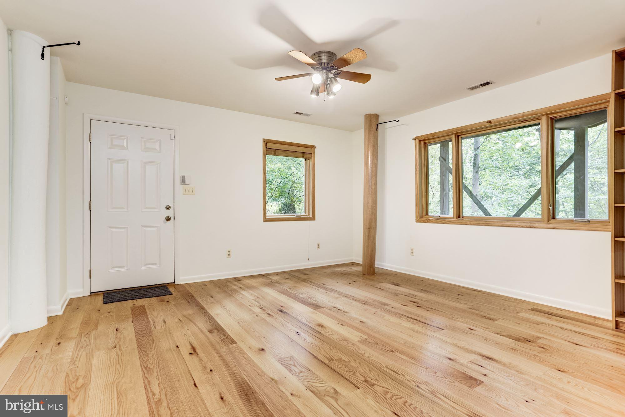 4511 Clifton Road Baltimore, MD 21216 - Photo 22 of 35 a view of an empty room with a window and wooden floor