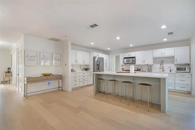 a kitchen with kitchen island granite countertop a large counter top and stainless steel appliances