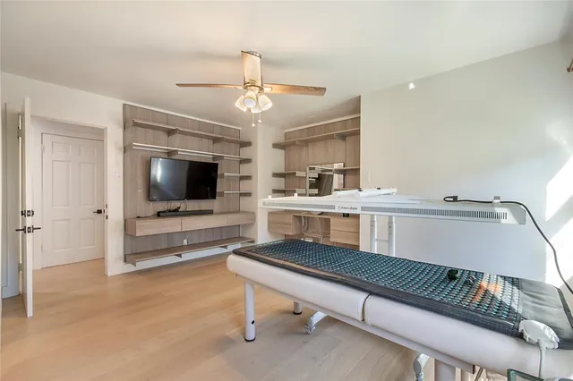 a bedroom with a large bed and ceiling fan