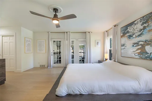 a bedroom with a large bed and a chandelier