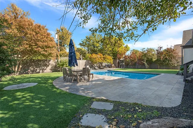 a view of a brick house with large windows and a small yard