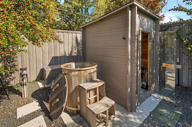 a view of a house with a small yard and wooden fence