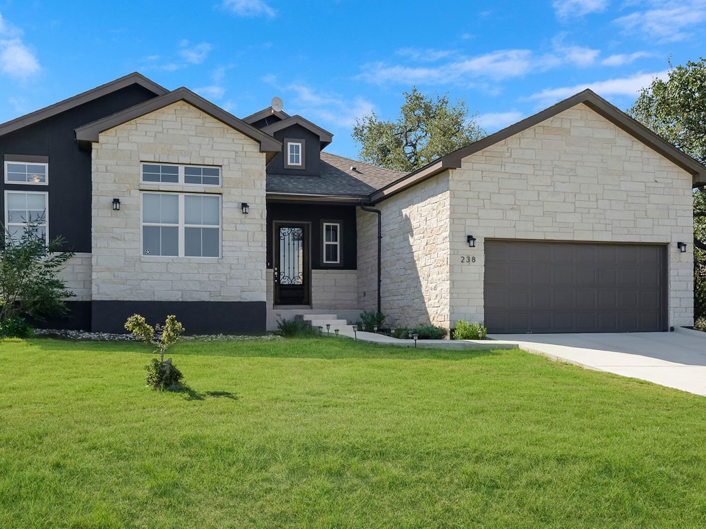 238 Roy Nichols Blanco, TX 78606 - Photo 3 of 25 a front view of a house with a yard and garage