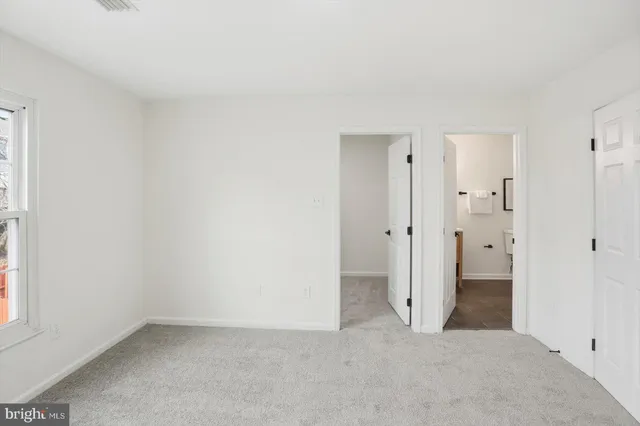 an empty room with white cabinet and door