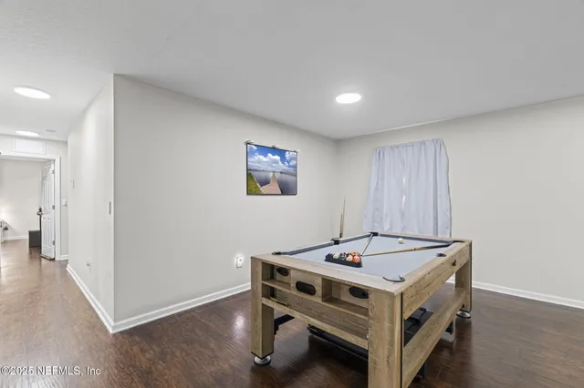 a utility room with stainless steel appliances wooden floor and large windows