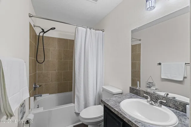 a bedroom with a bed and a flat tv screen on wall