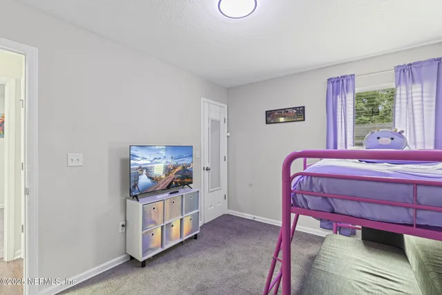 a bedroom with a bed and a painting on the wall