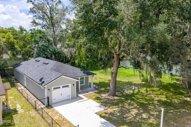 an aerial view of a house with swimming pool and garden