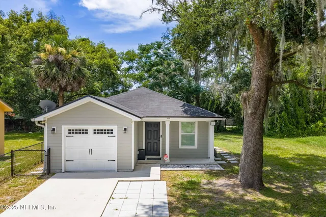 a view of a house with backyard and trees