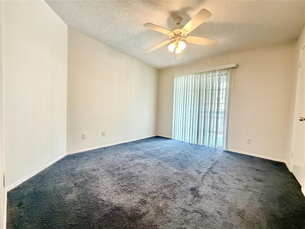18333 Roehampton Drive, Unit 624 Dallas, TX 75252 - Photo 11 of 39 an empty room with a chandelier fan and windows