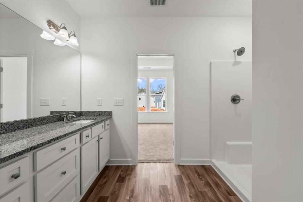 526 Lillian Way Statham, GA 30666 - Photo 20 of 56 a bathroom with a granite countertop sink a mirror and shower