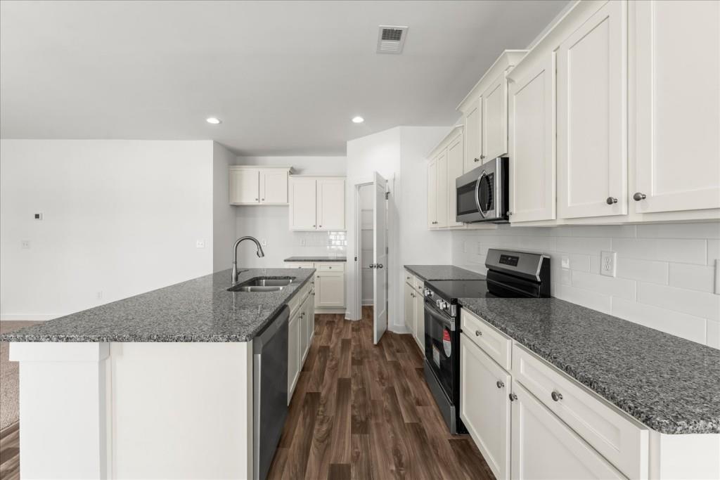 526 Lillian Way Statham, GA 30666 - Photo 24 of 56 a kitchen with granite countertop a sink stove and refrigerator