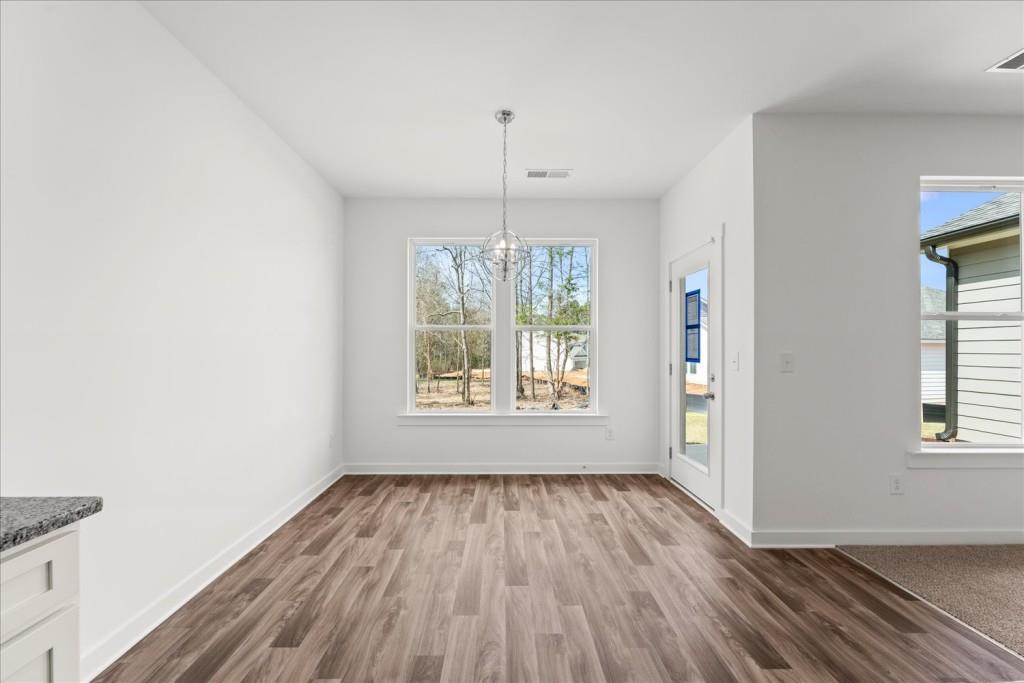 526 Lillian Way Statham, GA 30666 - Photo 25 of 56 a view of an empty room with wooden floor and a window