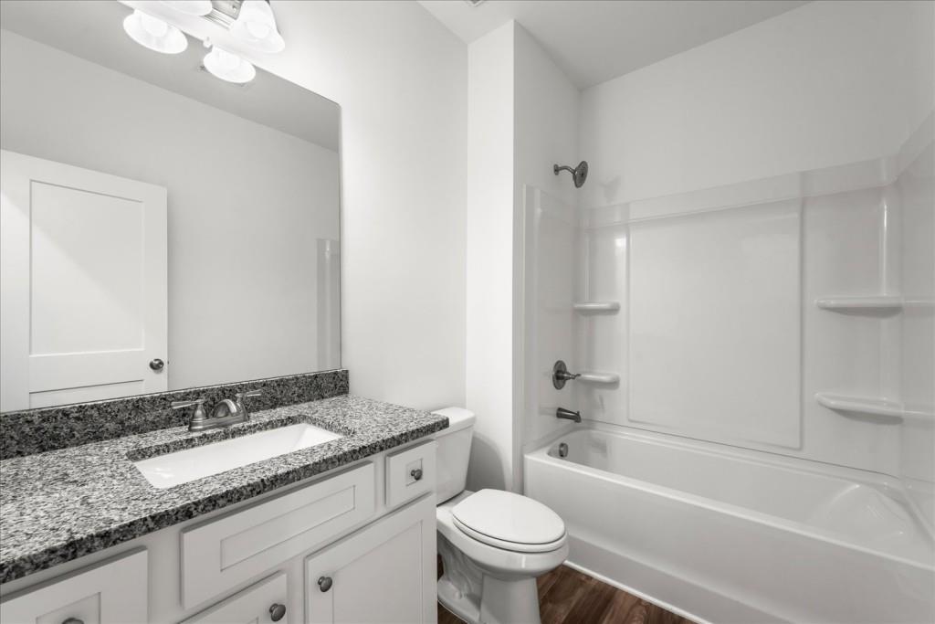 526 Lillian Way Statham, GA 30666 - Photo 6 of 56 a bathroom with a granite countertop sink toilet mirror and bathtub