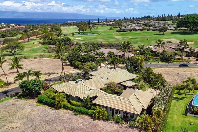 an aerial view of a house with a yard and lake view