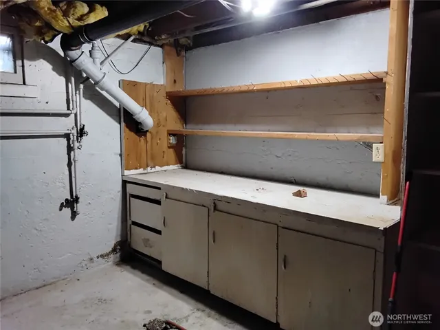 a backyard of a house with large trees and a wooden fence