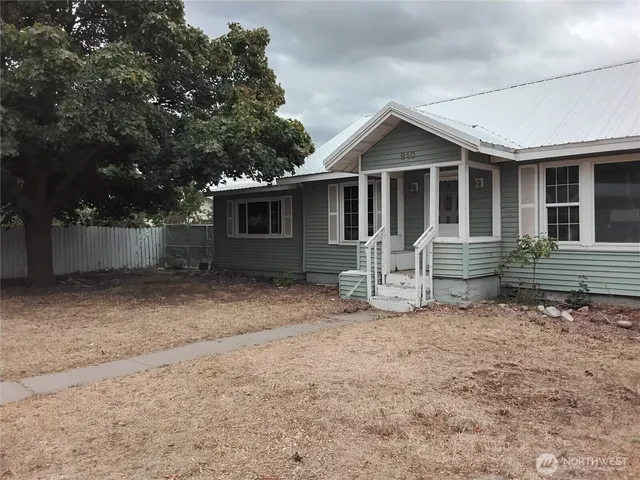 a front view of a house with yard and trees