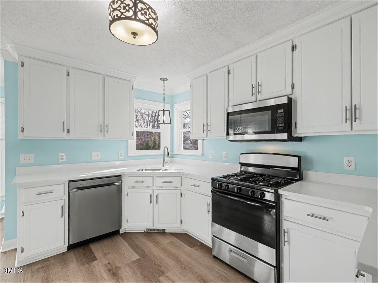 4828 Forest Highland Drive Raleigh, NC 27604 - Photo 2 of 27 a kitchen with cabinets stainless steel appliances and wooden floor