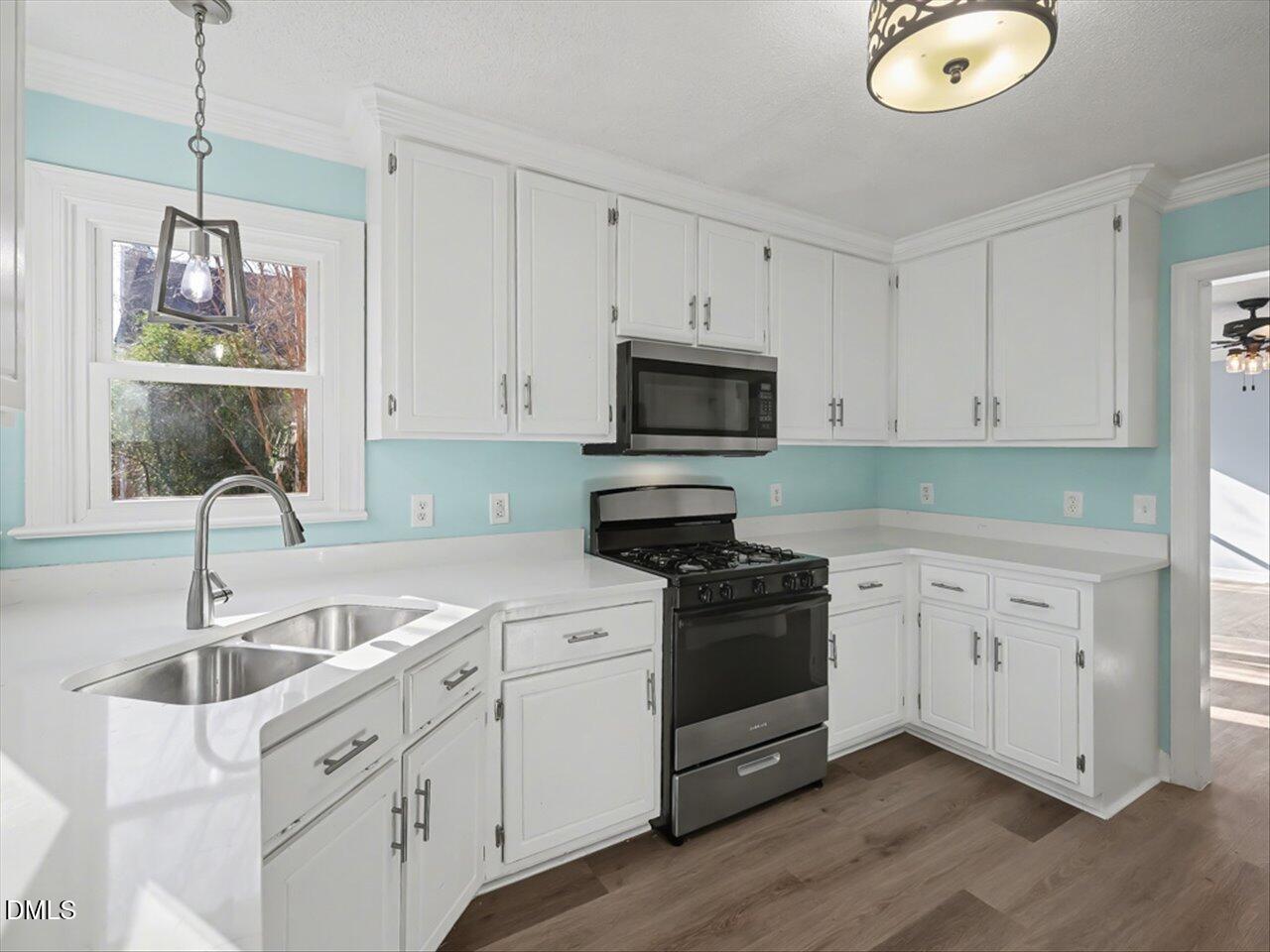 4828 Forest Highland Drive Raleigh, NC 27604 - Photo 4 of 27 a kitchen with white cabinets appliances and sink