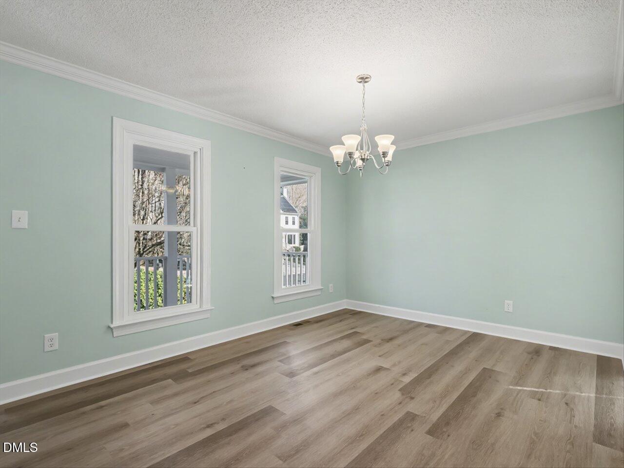 4828 Forest Highland Drive Raleigh, NC 27604 - Photo 7 of 27 a view of an empty room with wooden floor and a window