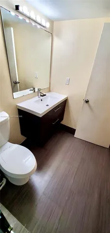a bathroom with a sink a toilet a mirror and vanity