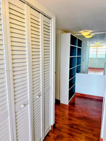 a view of empty room with wooden floor and windows