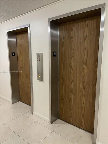 a front view of a building with entryway and garden