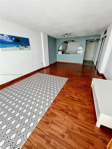 a bedroom with wooden floor and rug