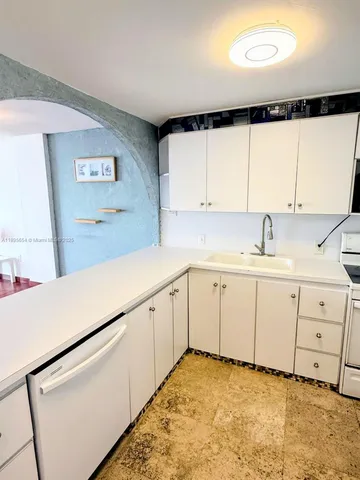 a room with a sink a mirror and cabinets