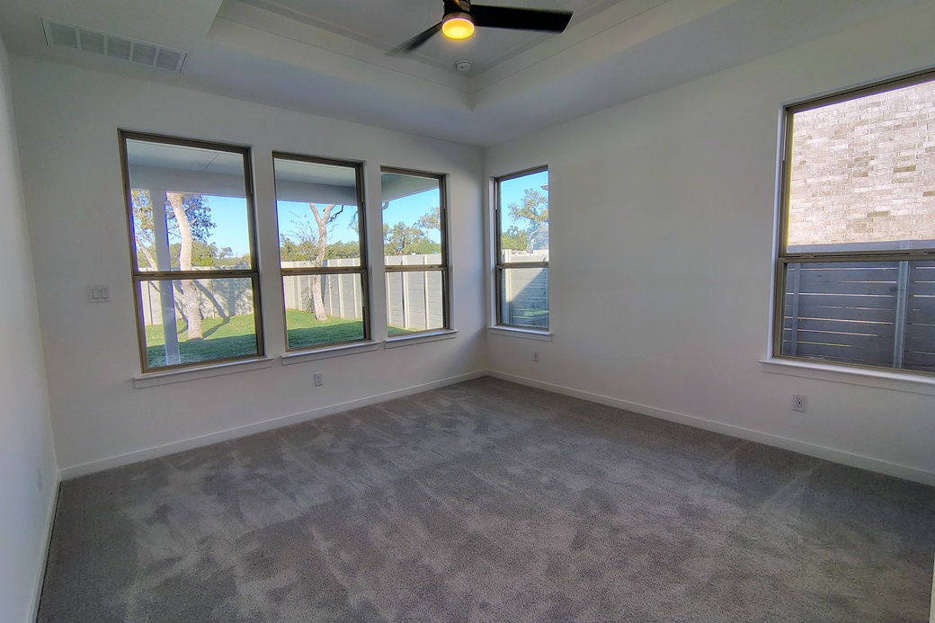 1804 Spg Mountain Cove Georgetown, TX 78628 - Photo 10 of 32 an empty room with chandelier fan and windows