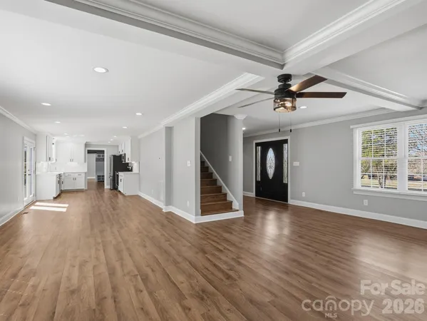 a view of a livingroom with wooden floor and a ceiling fan