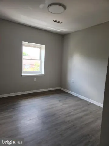 an empty room with wooden floor and a window