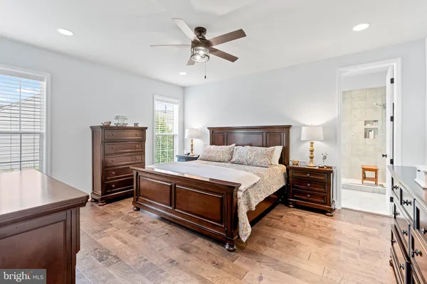 a bedroom with a bed dresser and a flat tv screen