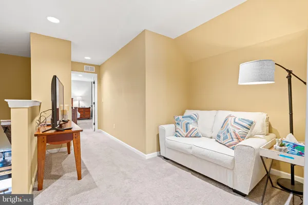 a living room with furniture and a book shelf