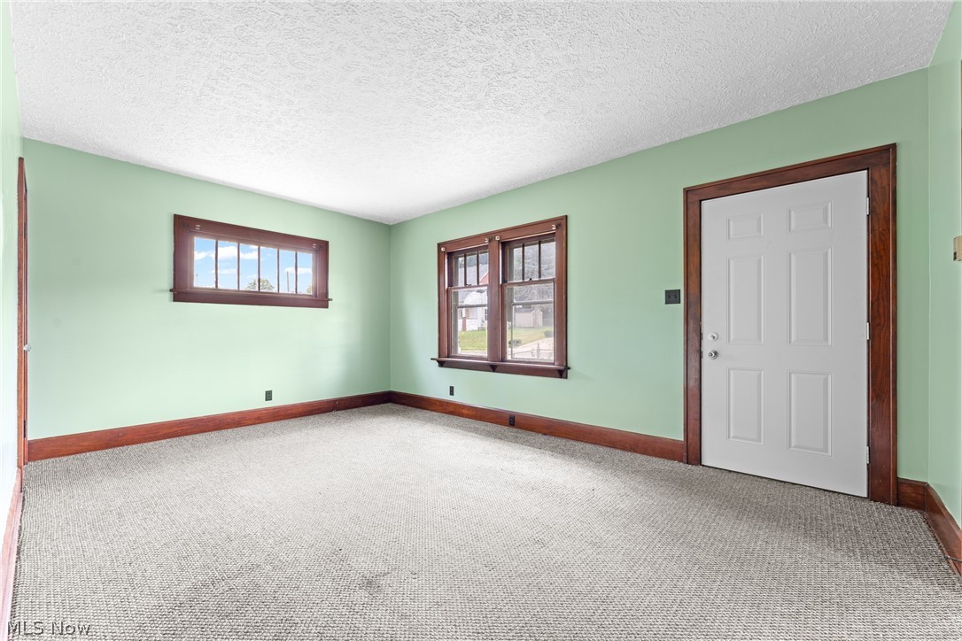 16 South State Street Rittman, OH 44270 - Photo 9 of 27 Carpeted spare room featuring a textured ceiling and plenty of natural light