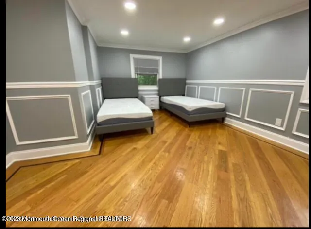 a spacious bedroom with a bed and wooden floor