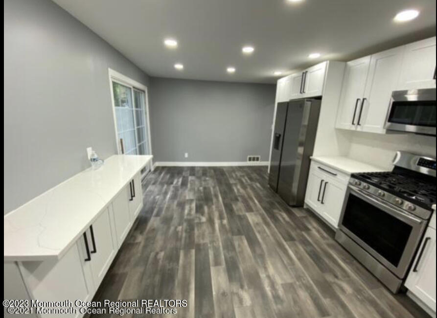 437 Redmond Avenue Oakhurst, NJ 07755 - Photo 6 of 26 a kitchen with kitchen island a stove a sink and a refrigerator