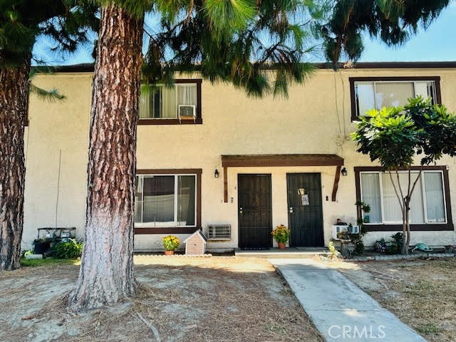 7304 Exeter Street, Unit E Paramount, CA 90723 - Photo 29 of 36 Mature pine trees and a well-kept lawn create a charming and inviting front yard setting.