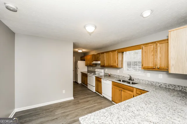 a large kitchen with stainless steel appliances granite countertop a sink and cabinets