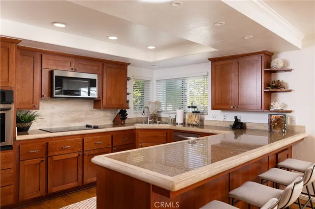 a kitchen with stainless steel appliances granite countertop a sink and a stove
