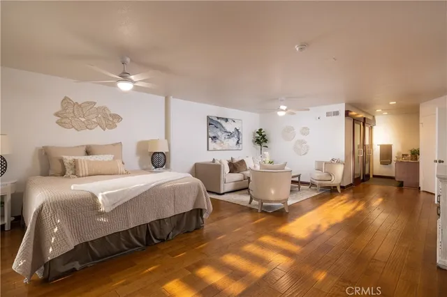 a spacious bedroom with a bed a couch and a chandelier