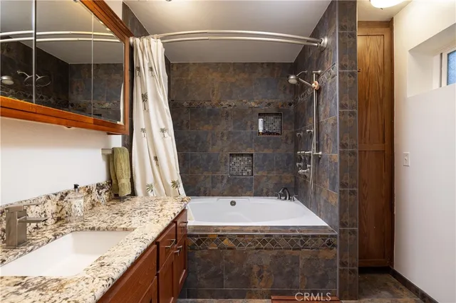 a bathroom with a granite countertop sink a shower and a mirror